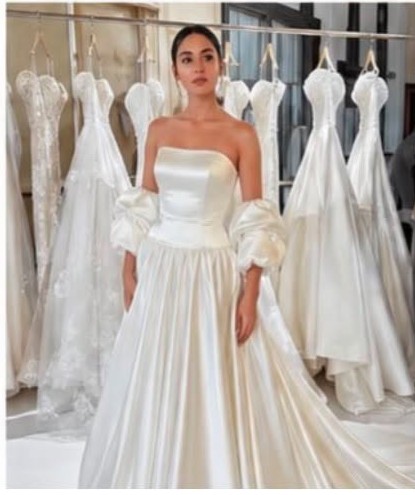 Lila B modelling a satin bridal gown in a bridal showroom