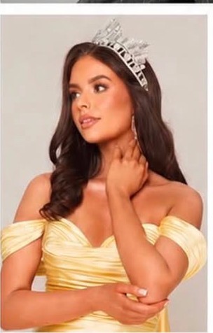 Jen K in a yellow occasionwear gown wearing a crown