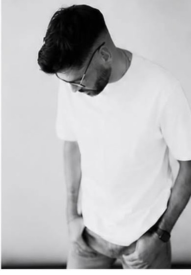 Brendan C in a white t-shirt, relaxed lifestyle studio portrait