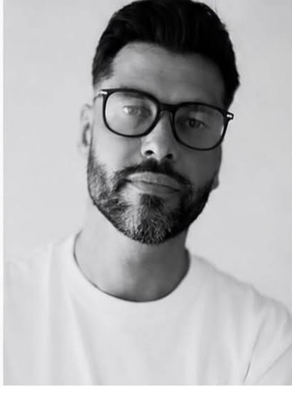 Brendan C close portrait wearing glasses in a white t-shirt